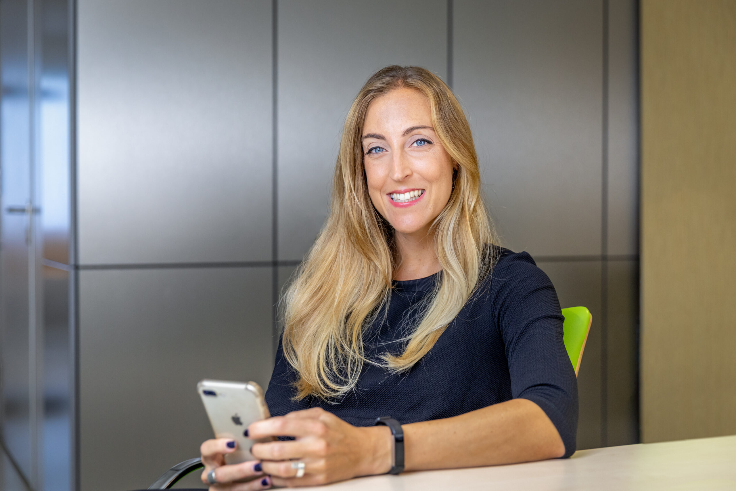 Mevrouw met telefoon aan bureau